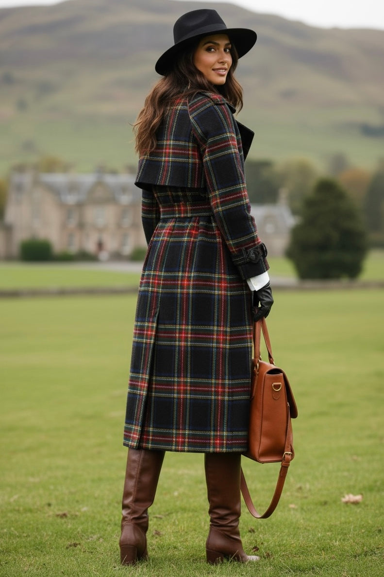 Woman wearing women's tartan trench coat with black hat brown boots and handbag outdoors