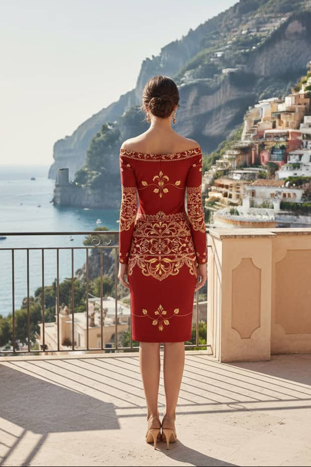 Woman wearing old money baroque inspired dress in red with gold ornate patterns overlooking scenic coastal town
